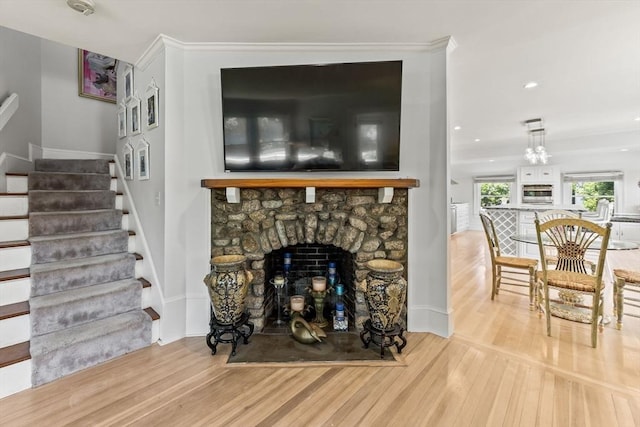 living area featuring wood finished floors, stairs, a fireplace, and recessed lighting