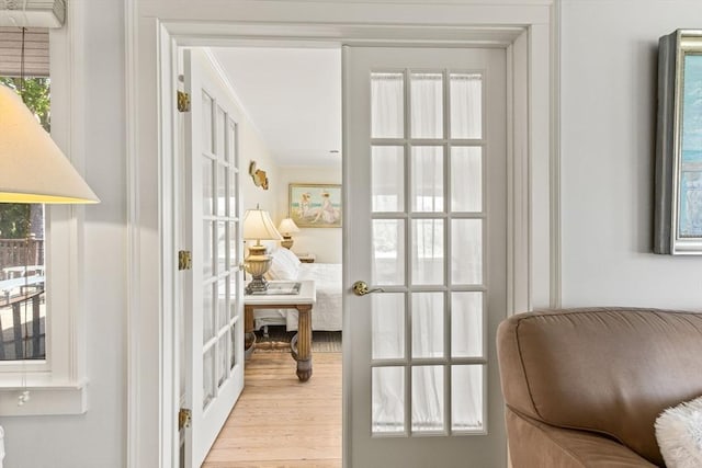 entryway featuring french doors, wood finished floors, and ornamental molding