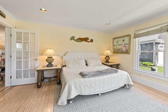 bedroom featuring wood finished floors, crown molding, baseboards, and recessed lighting