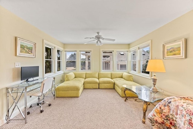carpeted living room with a desk, a ceiling fan, and baseboards