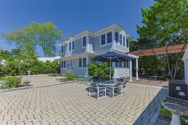 rear view of house featuring a pergola and a patio