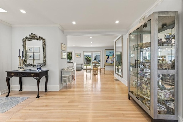 hall featuring light wood-style flooring, ornamental molding, baseboards, and recessed lighting