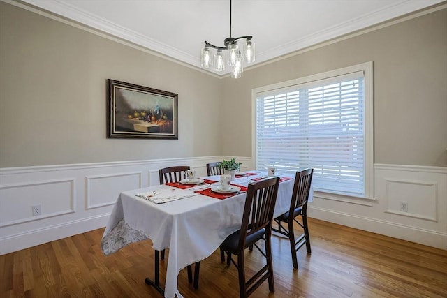 dining area featuring hardwood / wood-style floors, crown molding, and an inviting chandelier