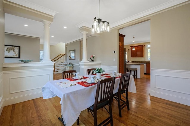 dining area with a chandelier, light hardwood / wood-style floors, and ornamental molding