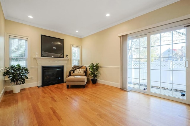 sitting room with light hardwood / wood-style flooring and ornamental molding