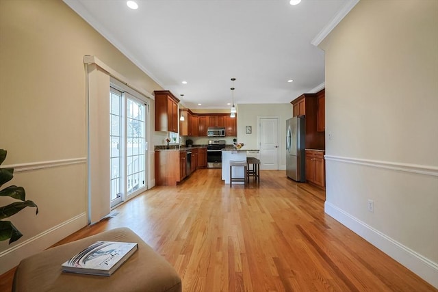 kitchen with decorative light fixtures, a kitchen breakfast bar, ornamental molding, and appliances with stainless steel finishes