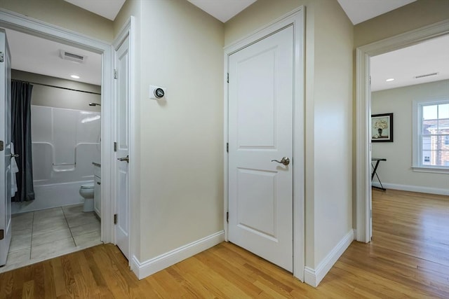 corridor with light hardwood / wood-style floors