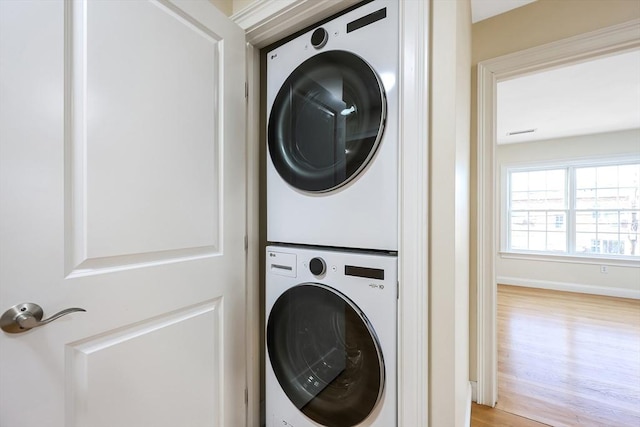 washroom featuring stacked washer / dryer and light wood-type flooring