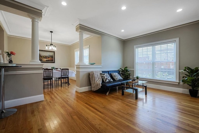 sitting room featuring hardwood / wood-style flooring, ornamental molding, and a notable chandelier