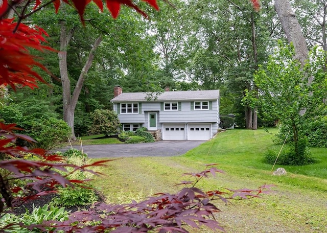 46 Plum St, Hamilton, MA 01982 - bi-level home with asphalt driveway, a chimney, a garage, and a front lawn
