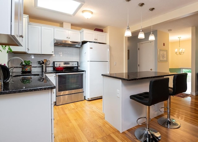 46 Plum St, Hamilton, MA 01982 - kitchen featuring stainless steel electric stove, freestanding refrigerator, under cabinet range hood, light wood-type flooring, and white cabinets