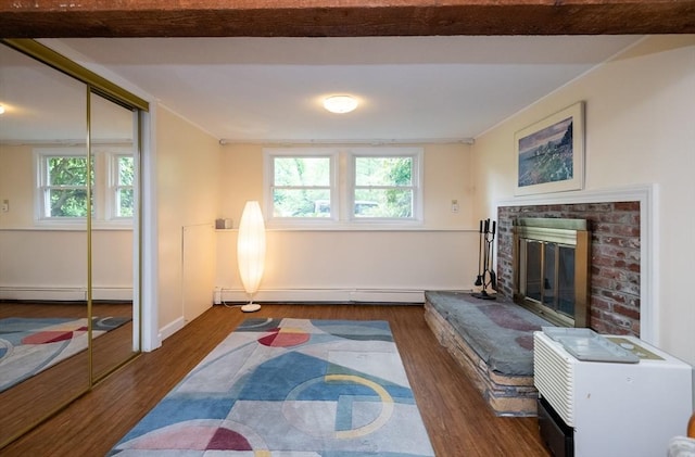 46 Plum St, Hamilton, MA 01982 - living area featuring a baseboard heating unit, wood finished floors, a brick fireplace, and plenty of natural light