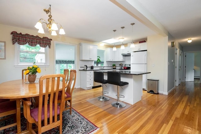46 Plum St, Hamilton, MA 01982 - kitchen with dark countertops, a center island, white cabinets, and light wood-style flooring