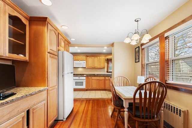 57 Taft St, Medford, MA 02155 - kitchen featuring radiator, white appliances, healthy amount of natural light, a chandelier, and recessed lighting