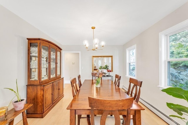 dining area with light wood-type flooring, healthy amount of natural light, a chandelier, and a baseboard heating unit
