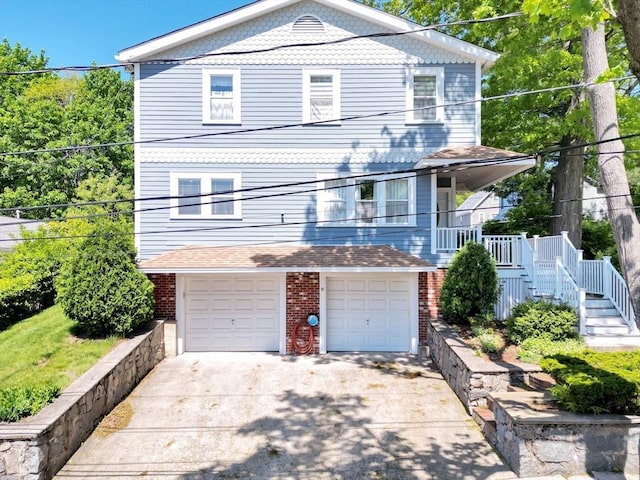 view of front of property with driveway, a garage, stairway, and brick siding