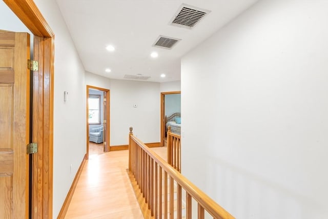 corridor featuring an upstairs landing, recessed lighting, light wood finished floors, and baseboards