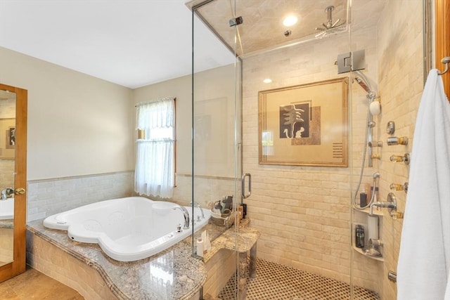 bathroom featuring a bath, a shower stall, and tile patterned floors