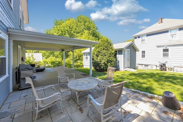 view of patio / terrace featuring an outbuilding, a storage unit, and grilling area