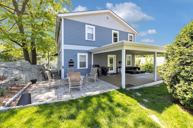 back of house with a patio area, an outdoor living space, and a yard