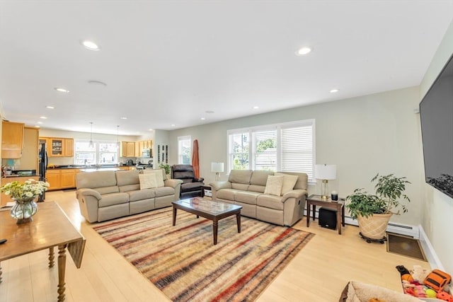living room featuring light wood-style flooring, recessed lighting, a baseboard radiator, and a baseboard heating unit