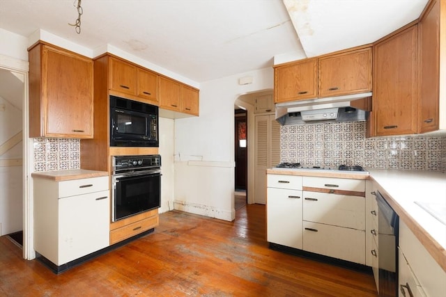 kitchen featuring tasteful backsplash, extractor fan, black appliances, and dark hardwood / wood-style floors