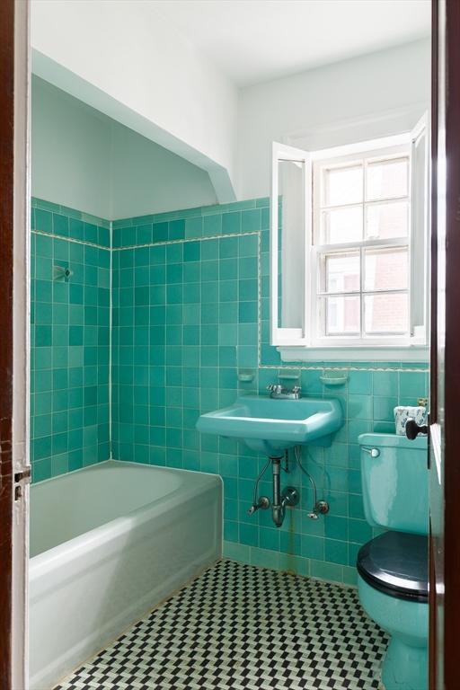 full bathroom with tile walls, sink, tile patterned flooring, and toilet