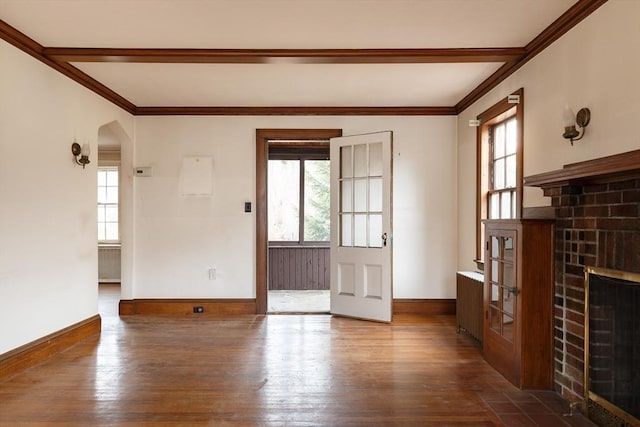 unfurnished living room featuring dark wood-type flooring, radiator heating unit, and a fireplace