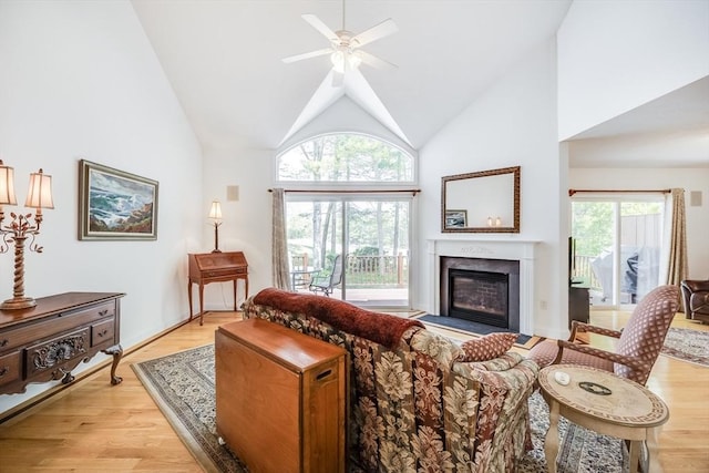 13 Laurel Hill Ct Unit 13, Bourne, MA 02532 - living area featuring a glass covered fireplace, healthy amount of natural light, ceiling fan, light wood finished floors, and high vaulted ceiling