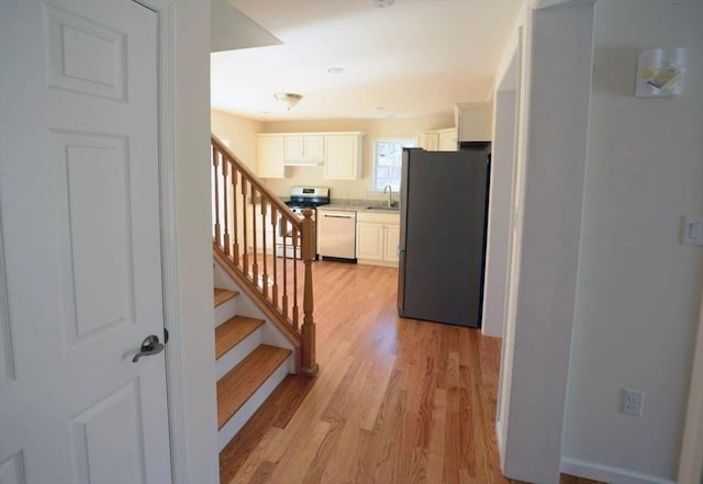 staircase with sink and hardwood / wood-style floors