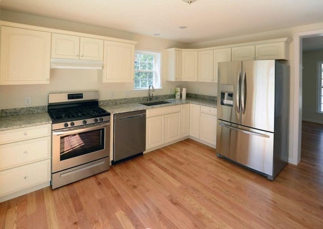 kitchen featuring white cabinetry, stainless steel appliances, sink, and light hardwood / wood-style flooring