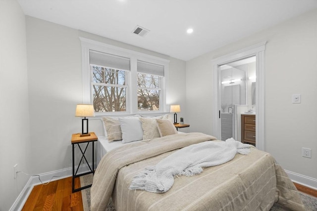 bedroom featuring ensuite bathroom and hardwood / wood-style floors