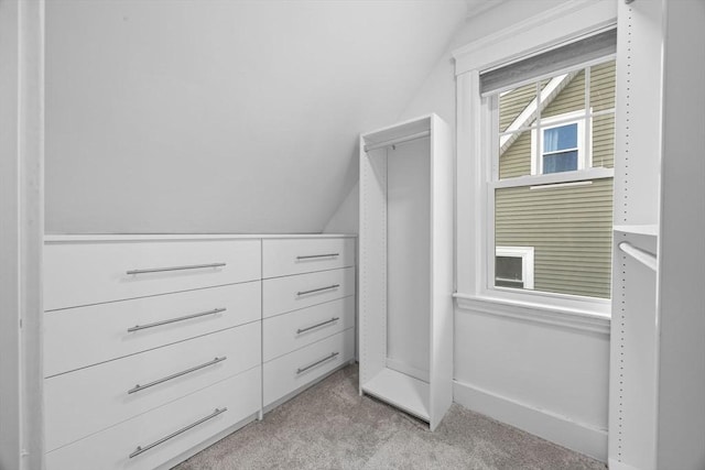 spacious closet with light colored carpet and lofted ceiling