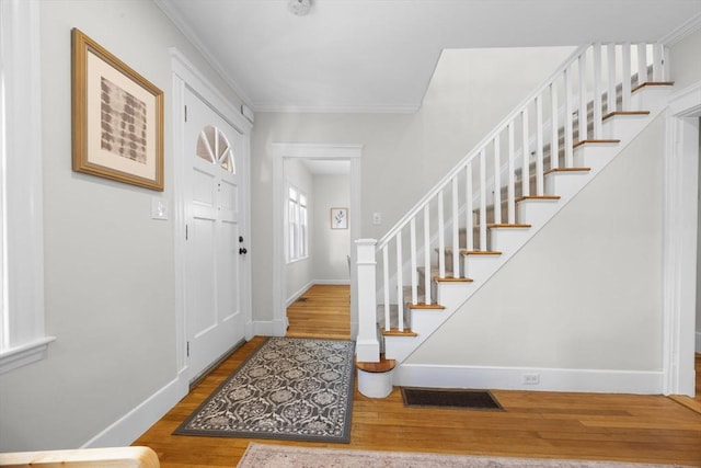 foyer with hardwood / wood-style floors and crown molding