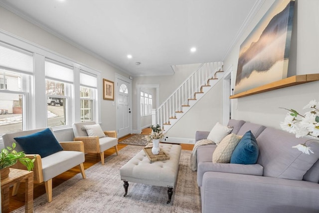 living room with a wealth of natural light, ornamental molding, and light hardwood / wood-style floors