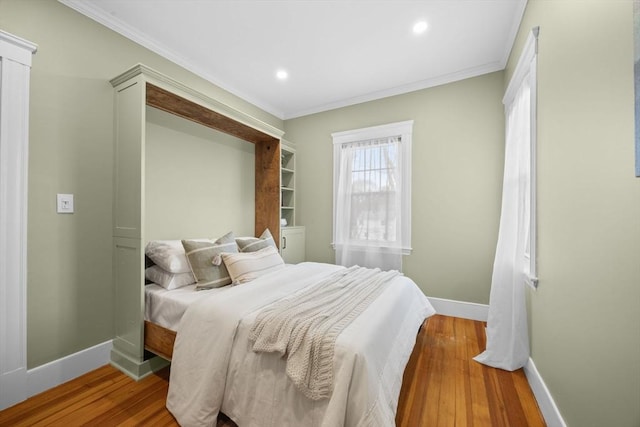 bedroom with ornamental molding and light hardwood / wood-style flooring