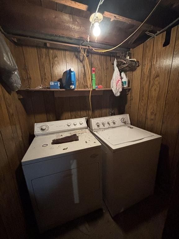 laundry area featuring separate washer and dryer, wood walls, and laundry area