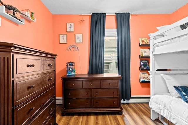109 Bouve Ave, Brockton, MA 02301 - bedroom with wood finished floors, a baseboard heating unit, and baseboards