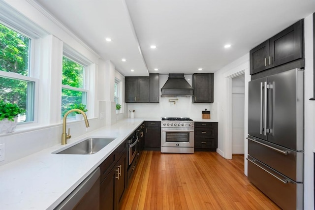 8 Carisbrooke St, Andover, MA 01810 - kitchen featuring premium appliances, custom exhaust hood, light wood-style flooring, and recessed lighting