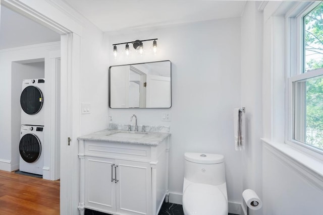8 Carisbrooke St, Andover, MA 01810 - bathroom with stacked washer and clothes dryer, vanity, and wood finished floors