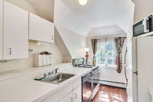 kitchen featuring freestanding refrigerator, dishwashing machine, baseboard heating, a sink, and gas stove