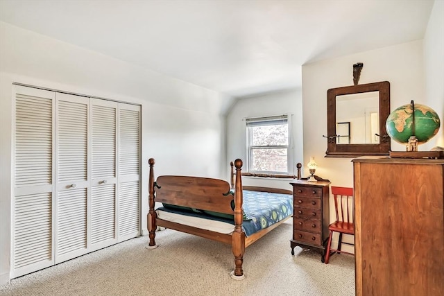 carpeted bedroom featuring a closet, baseboards, and lofted ceiling