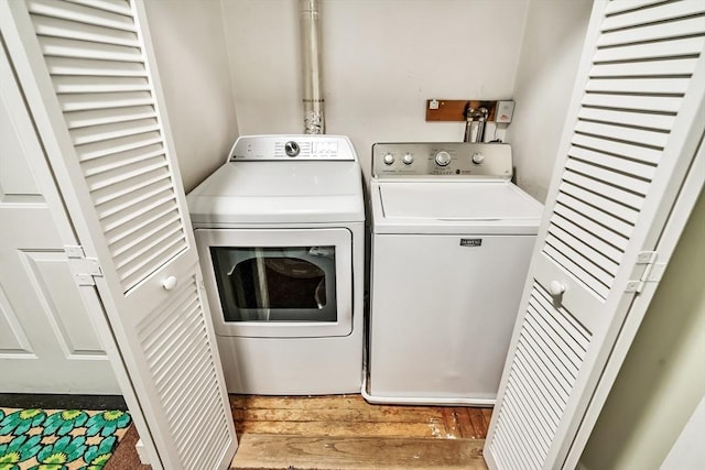 washroom featuring laundry area, wood finished floors, and washer and dryer