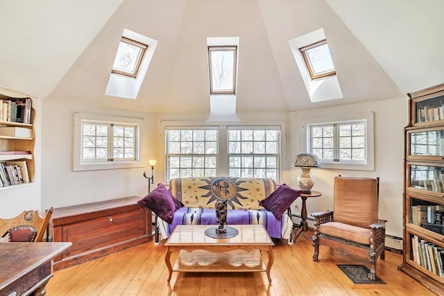 living area featuring a skylight, a healthy amount of sunlight, and high vaulted ceiling