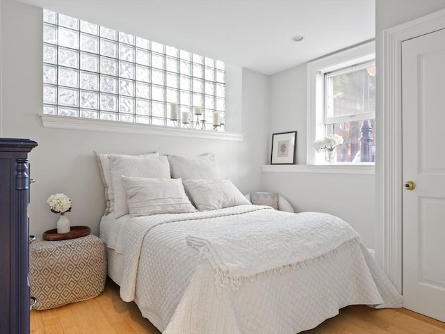 bedroom with wood finished floors and multiple windows