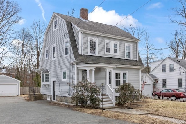 colonial inspired home featuring an outdoor structure, a gambrel roof, and roof with shingles