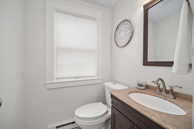 bathroom with vanity, toilet, and baseboard heating