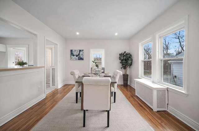 dining area featuring recessed lighting, radiator heating unit, wood finished floors, and baseboards