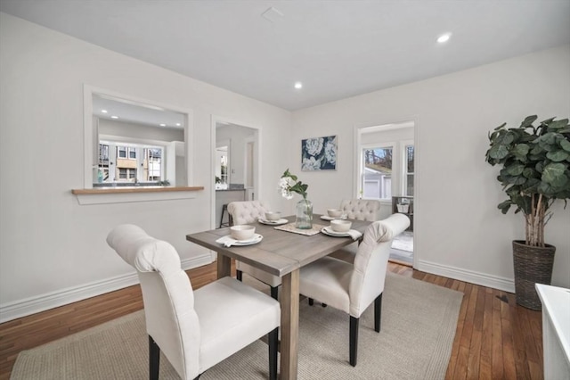 dining area with recessed lighting, plenty of natural light, wood finished floors, and baseboards