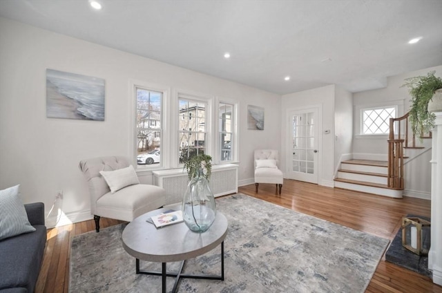 living room with recessed lighting, radiator heating unit, stairs, and wood finished floors